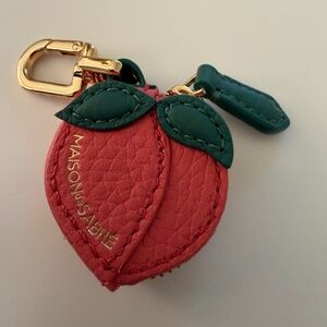 Maison de Sabre  strawberry bag charm with room to add an Apple AirTag.
